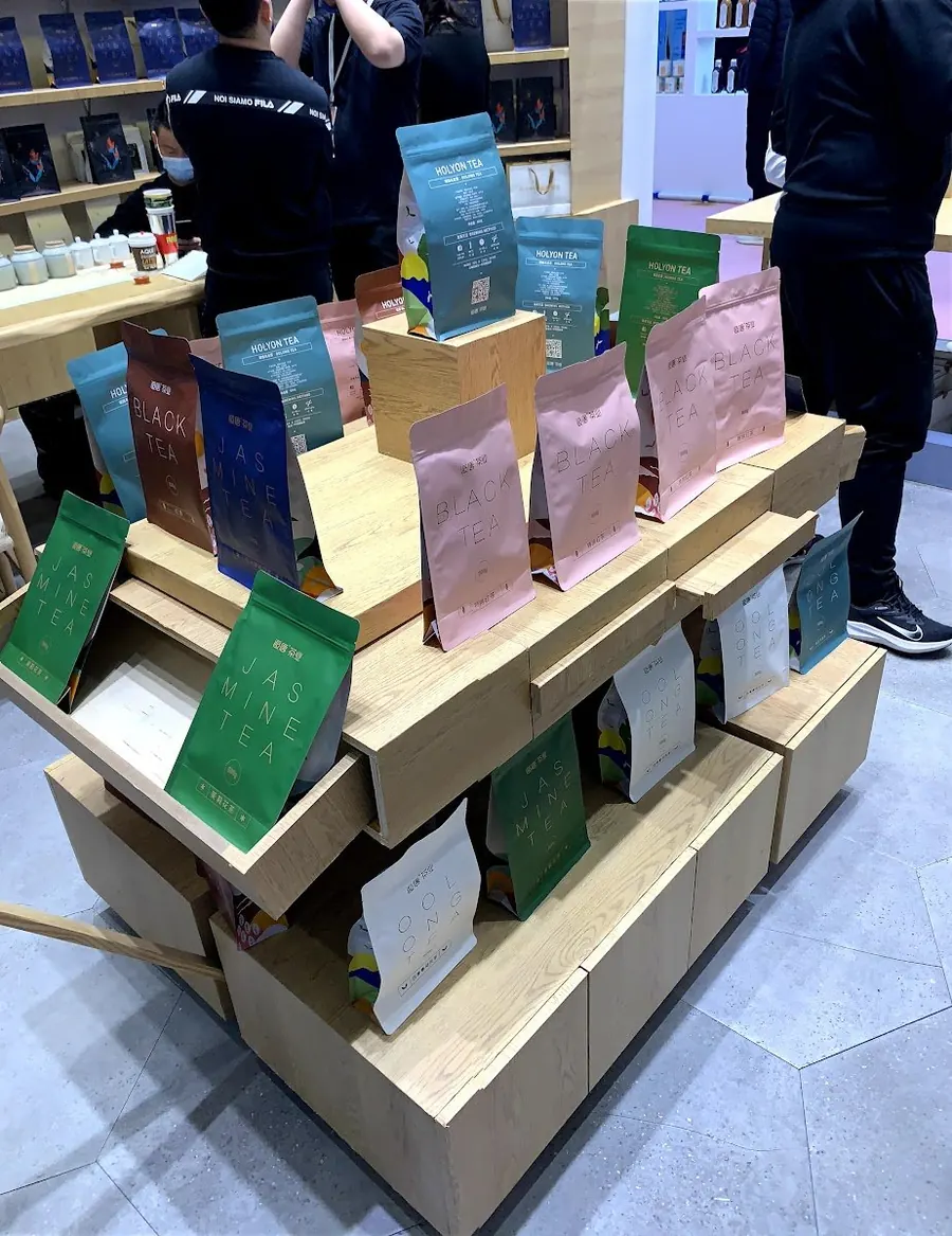 A tall display rack of printed stand-up pouches at a packaging fair